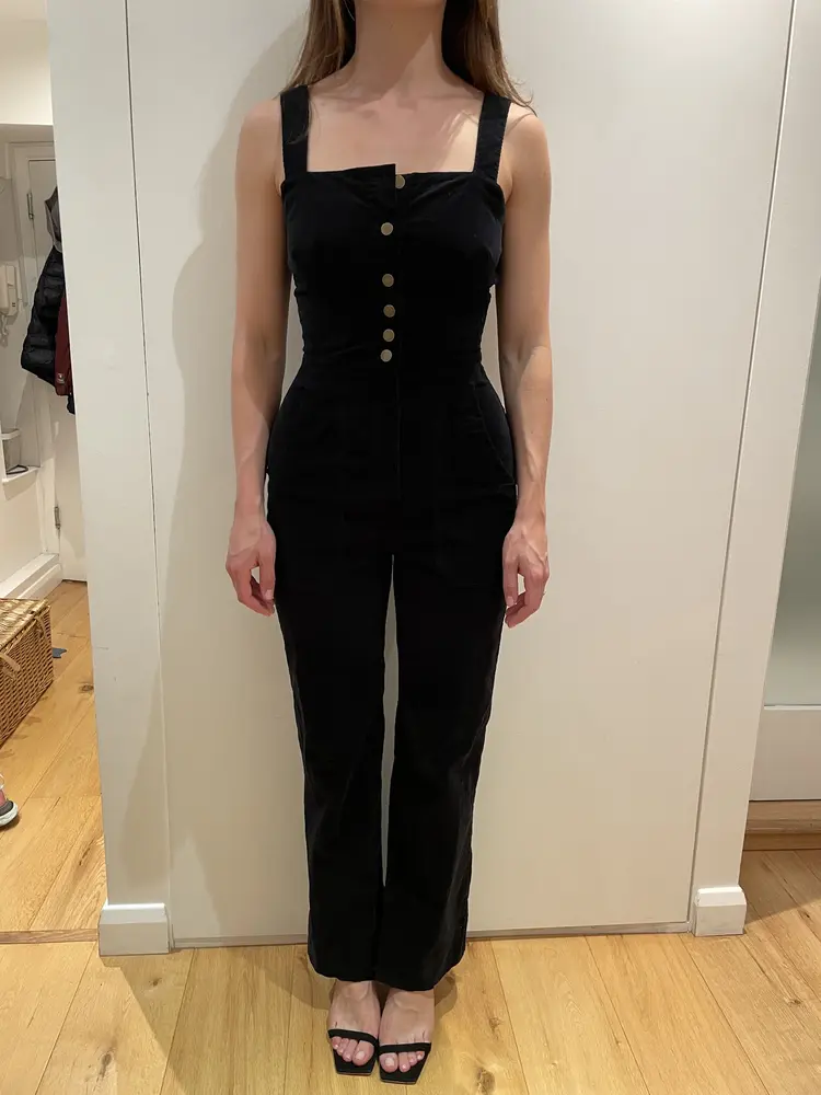 Black button-front jumpsuit fitted at the waist and hem